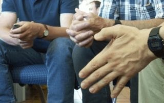 Photo of family members sitting in circle.