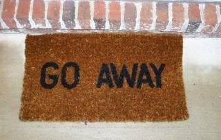 Photo of door mat saying, Go Away.
